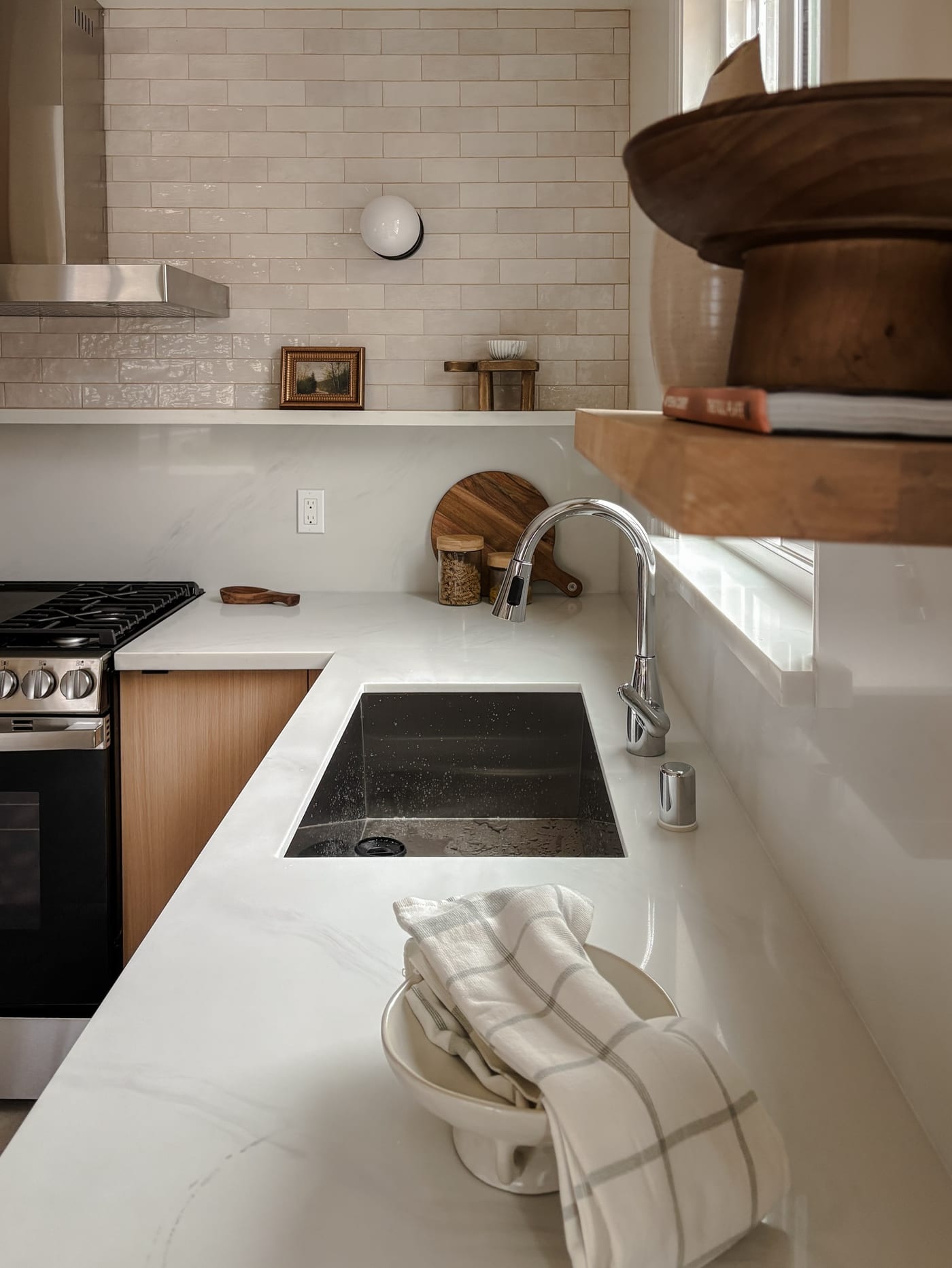 Staged kitchen with a marble countertop, undermount sink, and oak cabinets