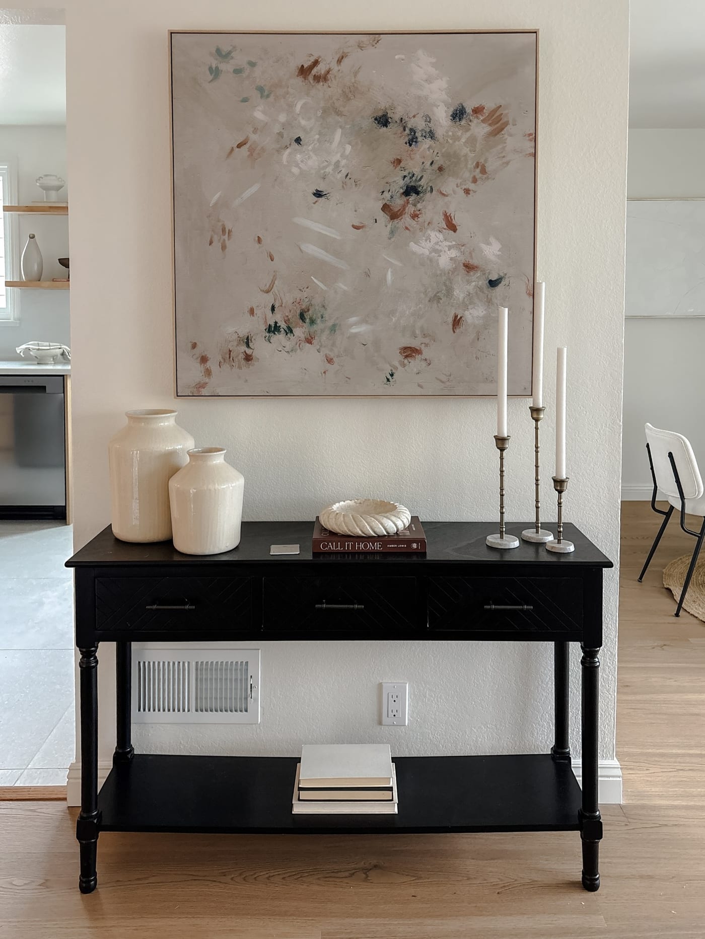 Styled entry console in black with abstract art and taper candles