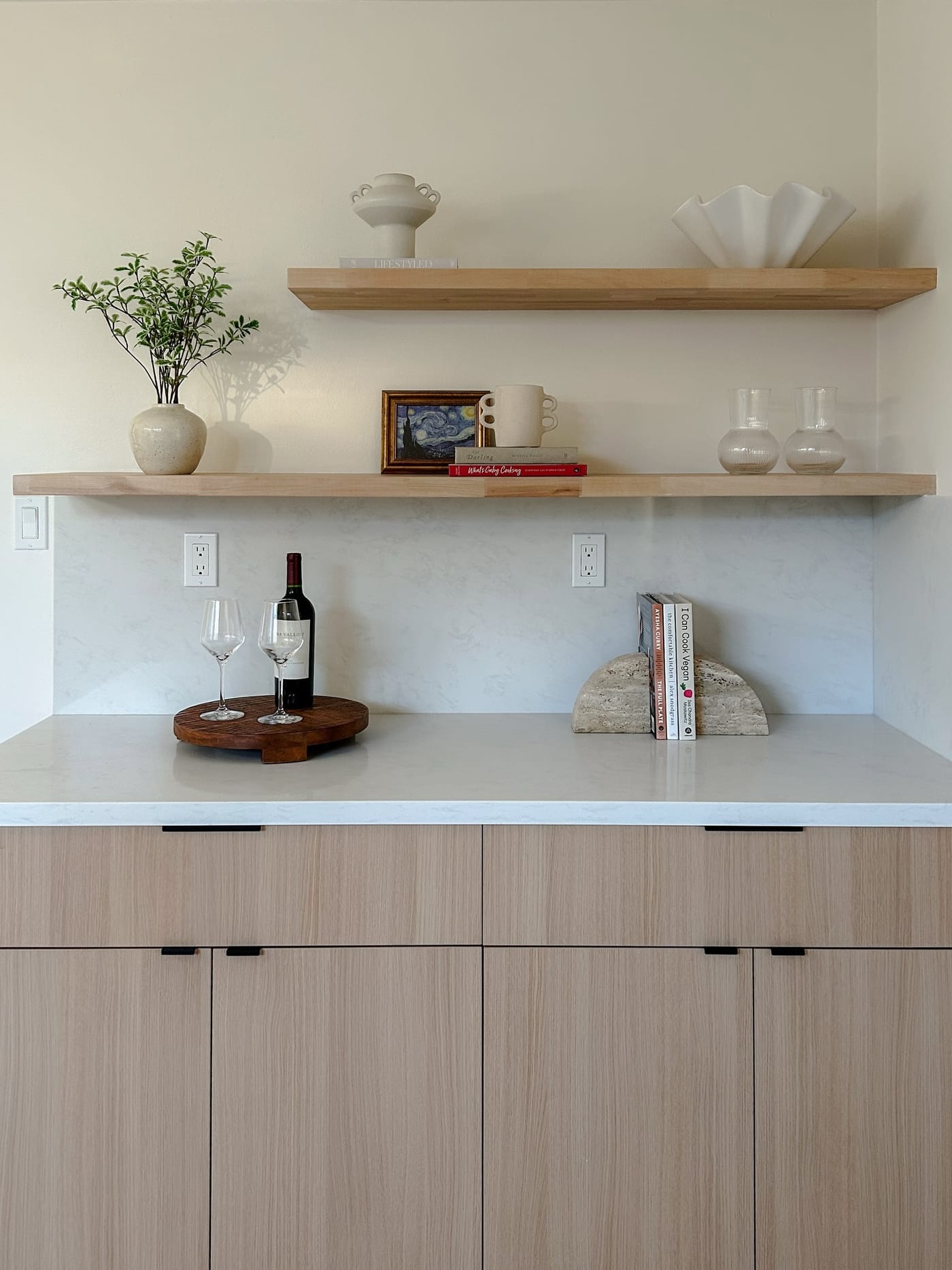 Styled dry bar with floating oak shelves, wine, and stemware