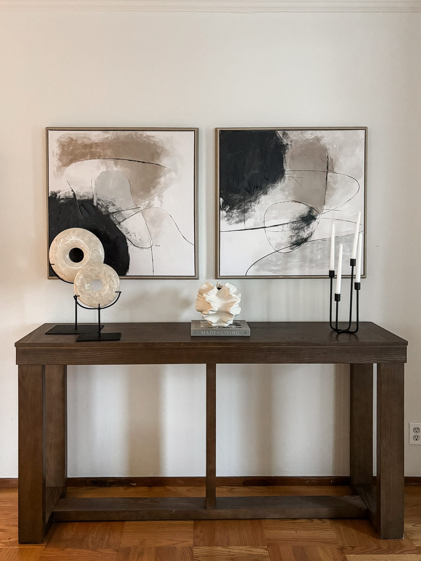 Styled entryway with a dark wood console and a pair of abstract canvases