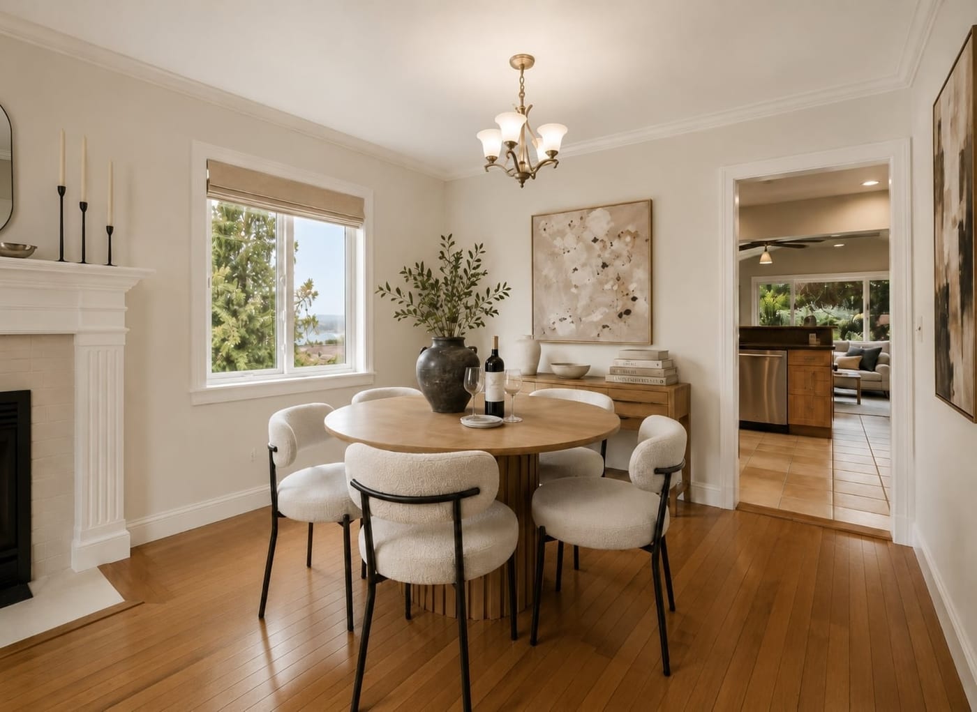 Staged dining room with a round table, boucle chairs, and a fireplace