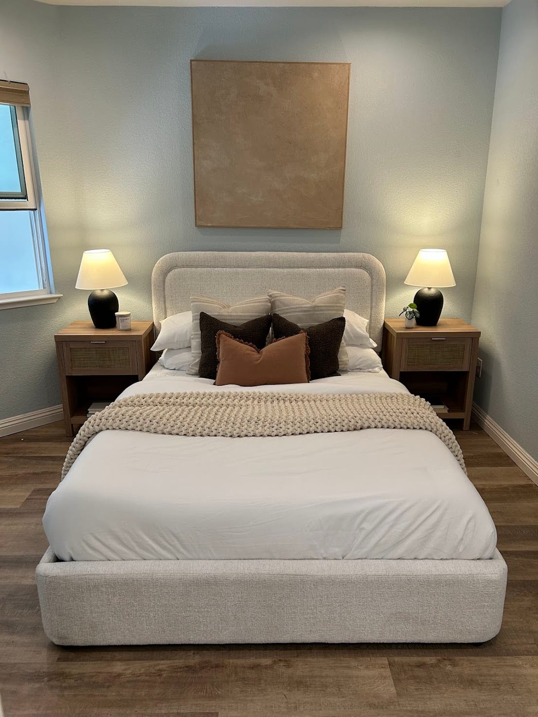 Staged bedroom with a boucle upholstered bed and warm neutral bedding