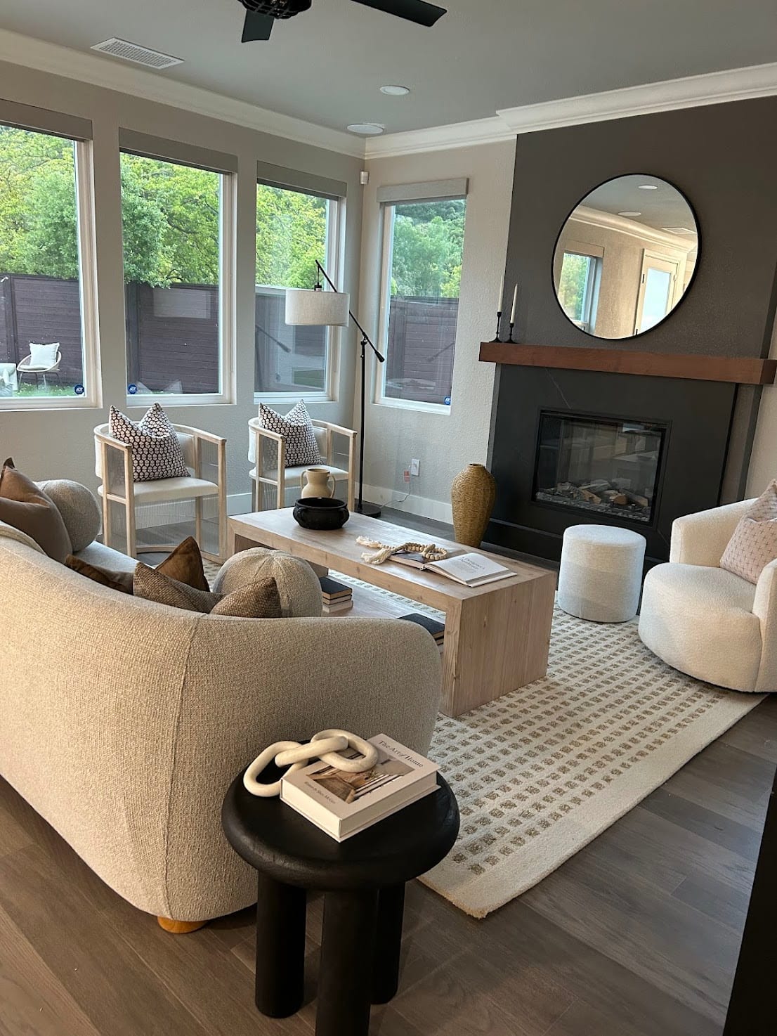 Staged living room with a boucle sofa, cane armchairs, and a marble fireplace