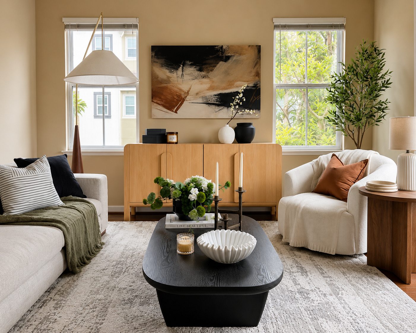 Staged living room with a cream sectional, a boucle armchair, an arched oak sideboard, and a brass tripod floor lamp